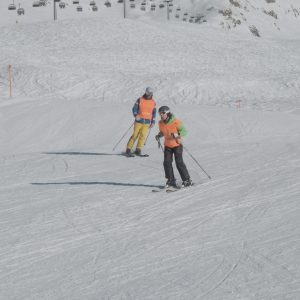 Abfahrender blinder Skifahrer mit seinem Guide/Skilehrer