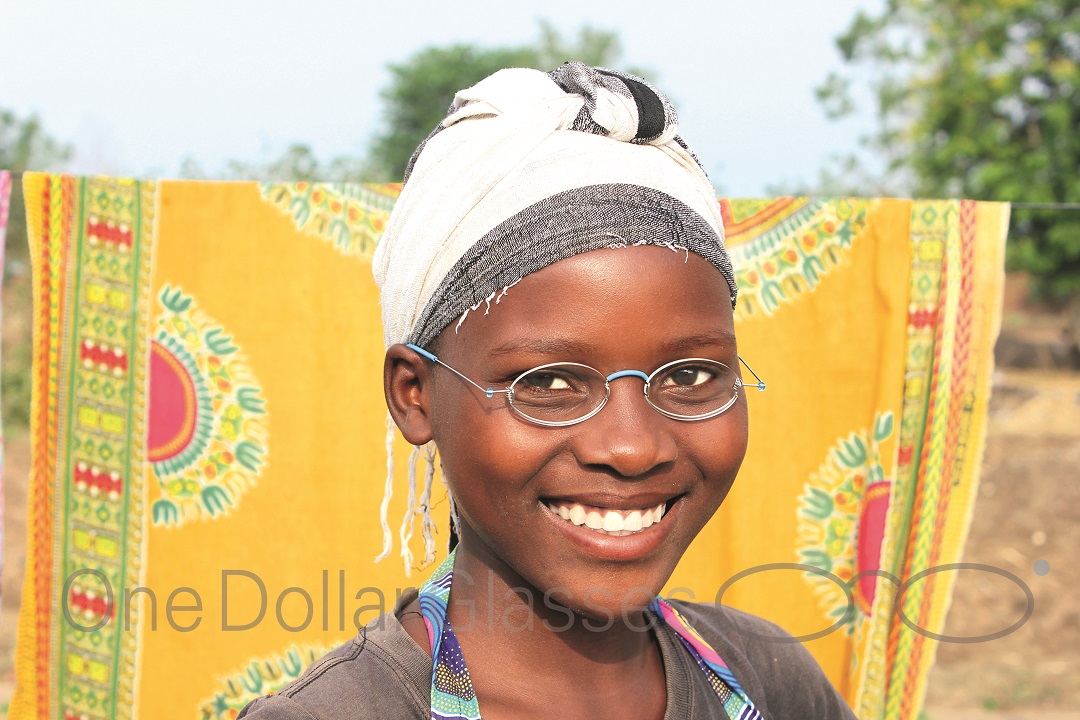 Ein Mädchen in Malawi lächelt glücklich in die Kamera. Sie trägt gerade ihre neue Brille.