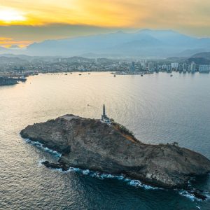 Die Bucht der Hafenstadt Santa Marta. Im Vordergrund sieht man die emblematische Felsinsel mit einem Leuchtturm